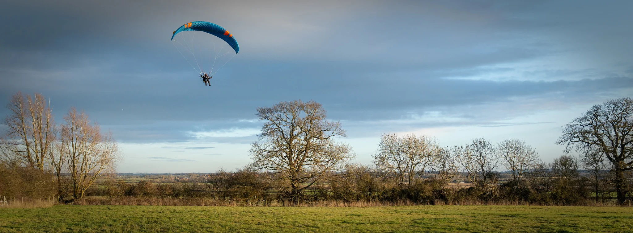 Paramotor flying over scenic landscape